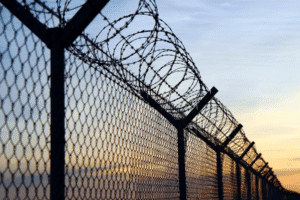 Arizona writ of habeas corpus representation with prison fence and barbed wire at sunset in Scottsdale