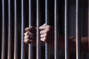 Arizona second-degree murder penalty represented by prisoner holding jail bars in Scottsdale