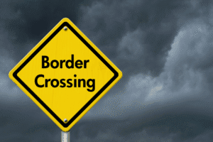 Border crossing warning sign under stormy Arizona sky – criminal immigration law concept