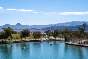 Lake Havasu boats on calm blue water with desert mountains and trees in Arizona