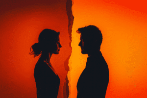 Couple facing each other separated by torn wall representing dissolution of marriage in Arizona