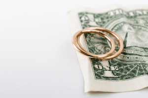 Wedding rings on dollar bill symbolizing cost of divorce in Arizona