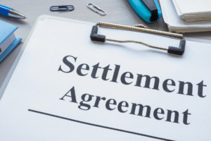 Close-up of a legal document titled “Settlement Agreement” on a clipboard, symbolizing a personal injury case resolution.