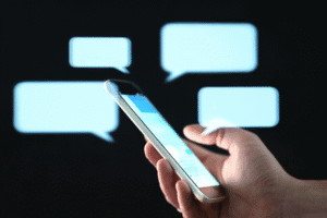 Hand holding smartphone with messaging screen, representing sexting laws in Arizona