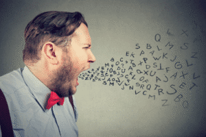 Man yelling with scattered letters symbolizing verbal abuse and emotional harm