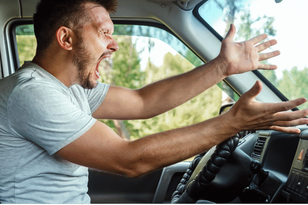 Man shouting and gesturing angrily while driving, representing road rage in Arizona.