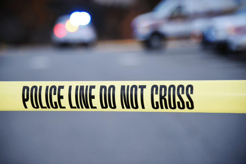 Police tape at Arizona crime scene with blurred emergency vehicles in background