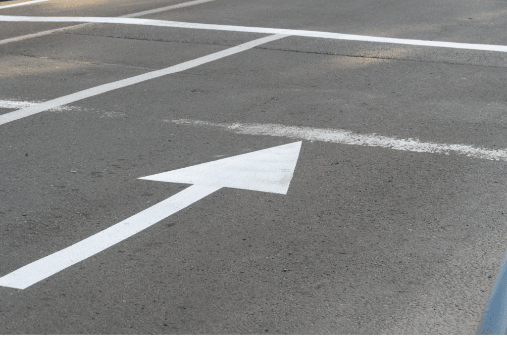 White directional arrow on Scottsdale road surface, guiding traffic flow