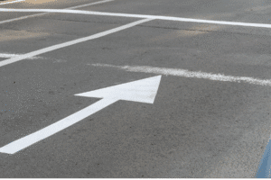 White directional arrow on Scottsdale road surface, guiding traffic flow