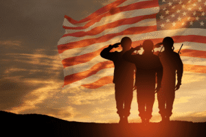 Veterans saluting with American flag at sunset – Arizona Veterans Court representation